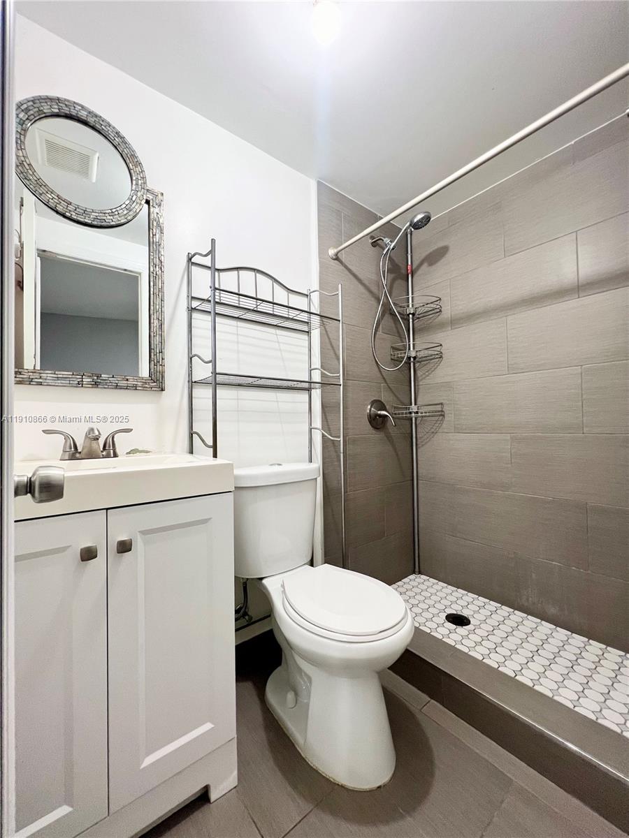 1400 Southwest 29th Avenue, Unit 3 Miami, FL 33145 - Photo 4 of 4 a bathroom with a sink a toilet a mirror and shower
