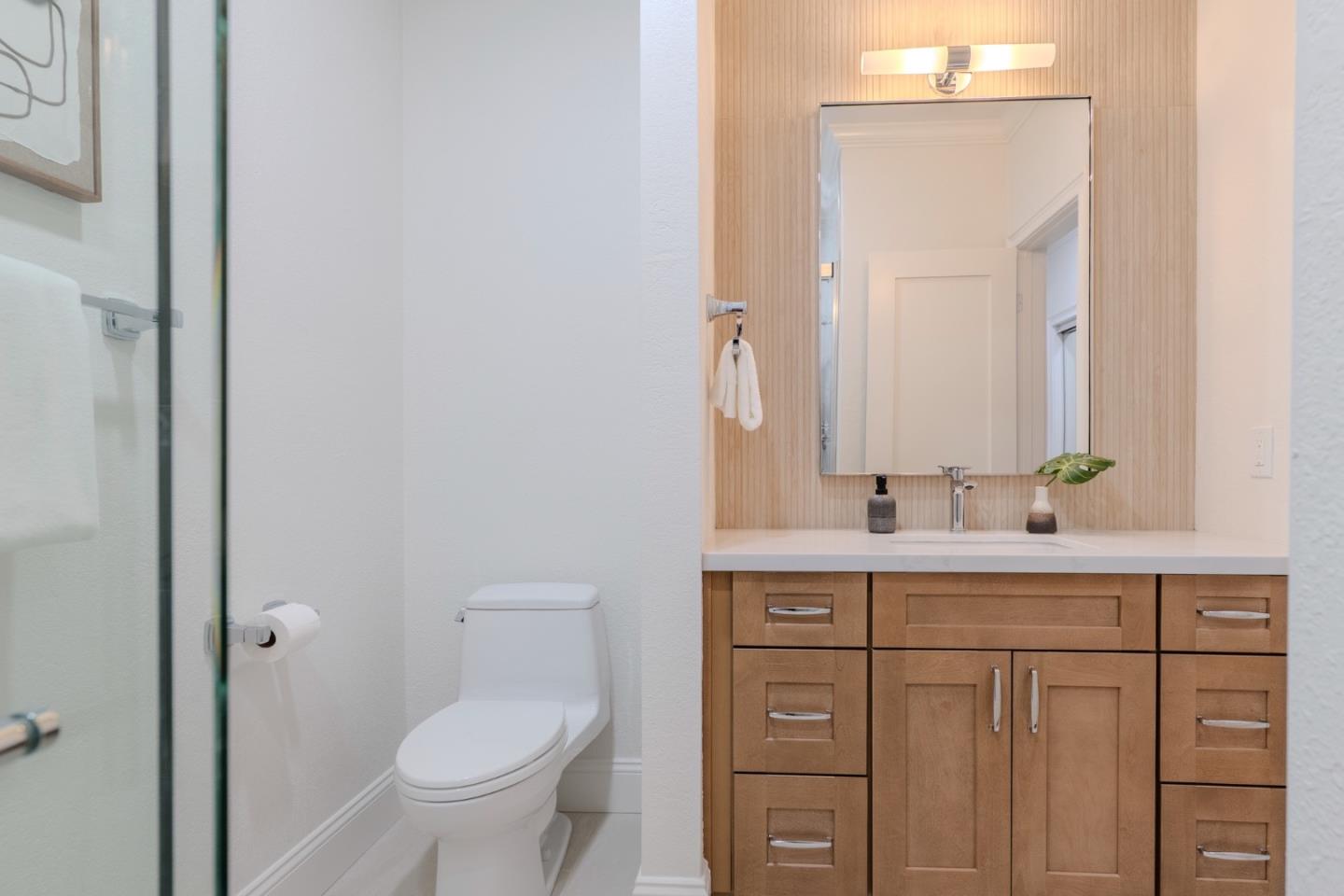 22330 Homestead Road, Unit 116 Cupertino, CA 95014 - Photo 24 of 30 a bathroom with a toilet a sink a vanity and mirror