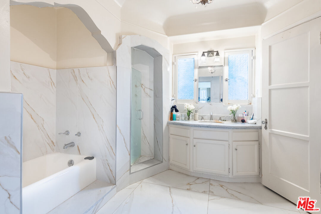 340 South Reeves Drive Beverly Hills, CA 90212 - Photo 14 of 35 a bathroom with a bathtub sink and mirror