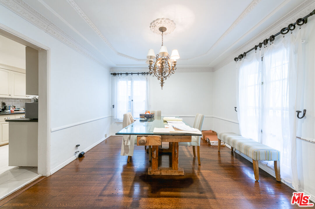 340 South Reeves Drive Beverly Hills, CA 90212 - Photo 20 of 35 a dining room with wooden floor a chandelier a wooden table and chairs