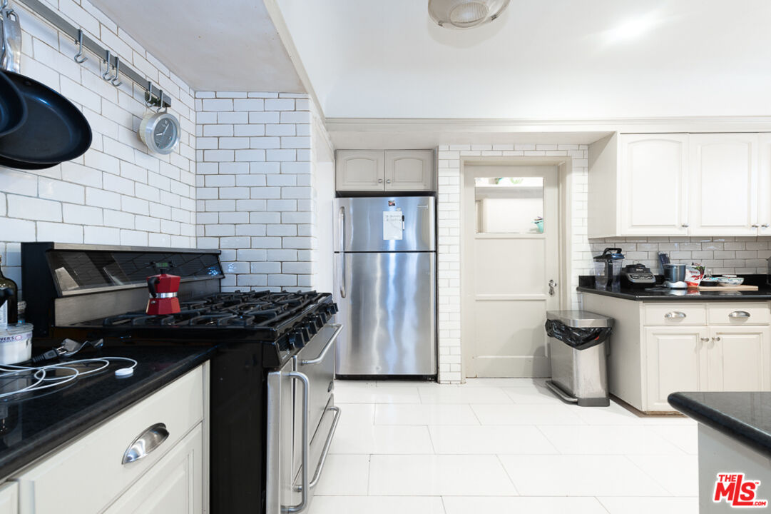 340 South Reeves Drive Beverly Hills, CA 90212 - Photo 21 of 35 a kitchen with stainless steel appliances granite countertop a stove a sink and a refrigerator