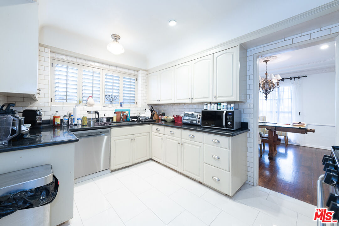 340 South Reeves Drive Beverly Hills, CA 90212 - Photo 22 of 35 a kitchen with stainless steel appliances white cabinets a sink and a stove
