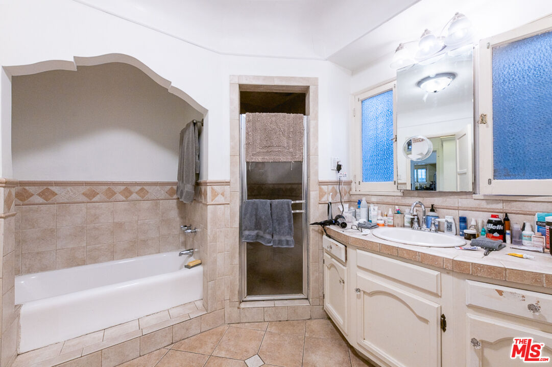 340 South Reeves Drive Beverly Hills, CA 90212 - Photo 30 of 35 a bathroom with a bathtub sink and mirror