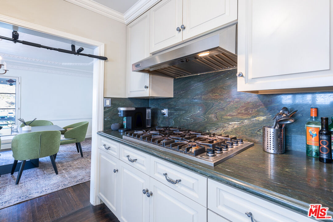 340 South Reeves Drive Beverly Hills, CA 90212 - Photo 9 of 35 a kitchen with stainless steel appliances granite countertop a sink and cabinets