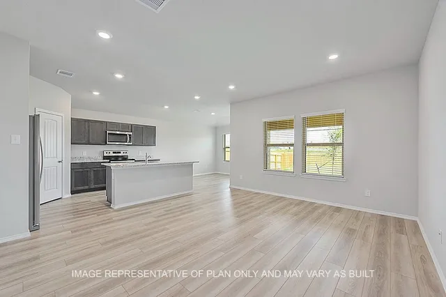 a large kitchen with kitchen island a sink dishwasher a stove and a refrigerator with wooden floor