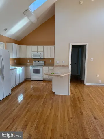 a kitchen with wooden floors and appliances
