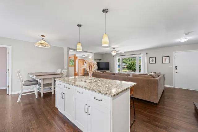 a view of kitchen island with granite countertop couches with wooden floor