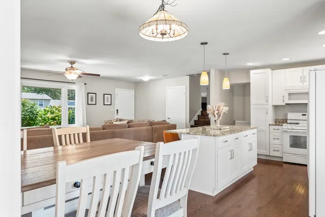 a kitchen that has a lot of white cabinets and stainless steel appliances