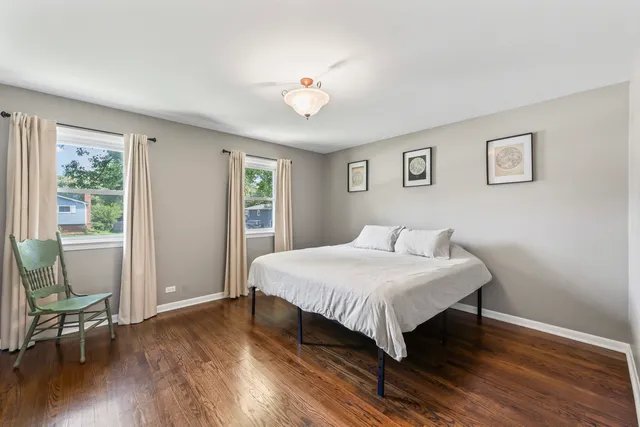 a bedroom with a bed and a table in it with wooden floor