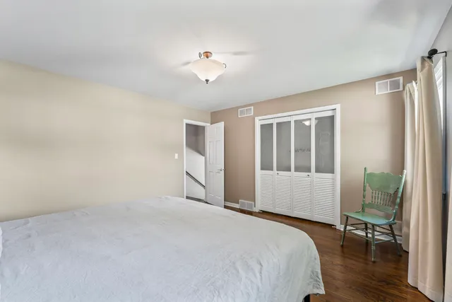 a bedroom with a bed wooden floor and a window