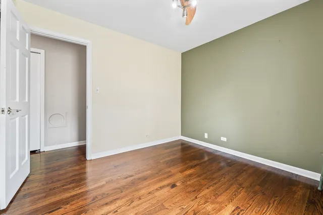 an empty room with wooden floor and entrance