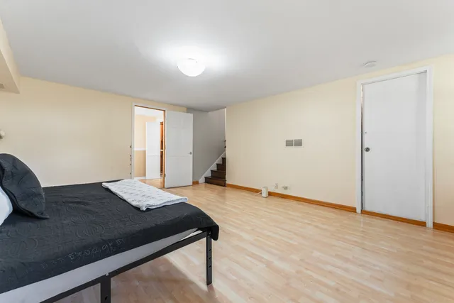 a bedroom with a bed and wooden floor