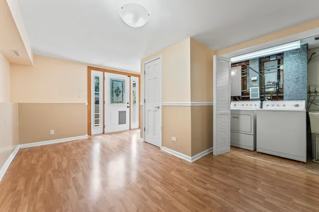 a view of a kitchen with wooden floor electronic appliances and windows