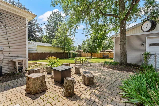 a view of a patio with table and chairs and a barbeque