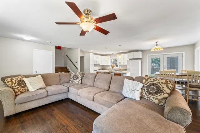 a living room with furniture kitchen view and a large window