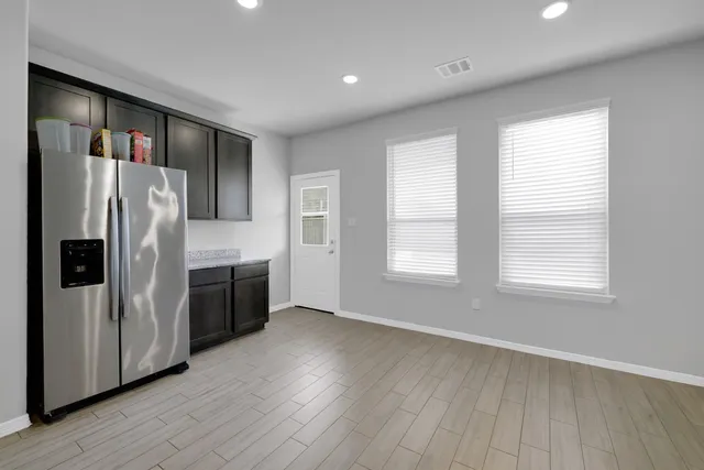 a kitchen with stainless steel appliances a refrigerator and a stove top oven
