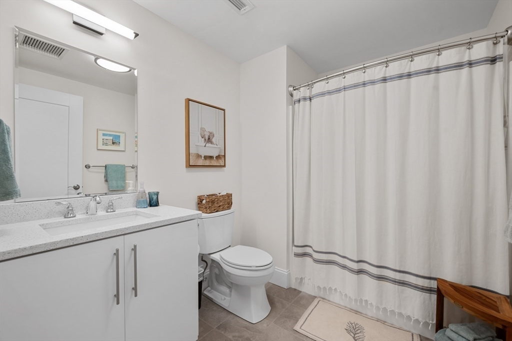 60 Merrimac Street, Unit 504 Amesbury, MA 01913 - Photo 28 of 37 a bathroom with a toilet a sink and a mirror