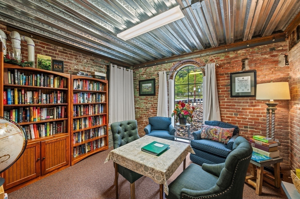 60 Merrimac Street, Unit 504 Amesbury, MA 01913 - Photo 36 of 37 a living room with furniture and a book shelf