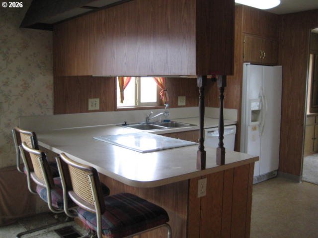 5355 River Road North, Unit 98 Keizer, OR 97303 - Photo 23 of 34 a kitchen with a table chairs and a refrigerator