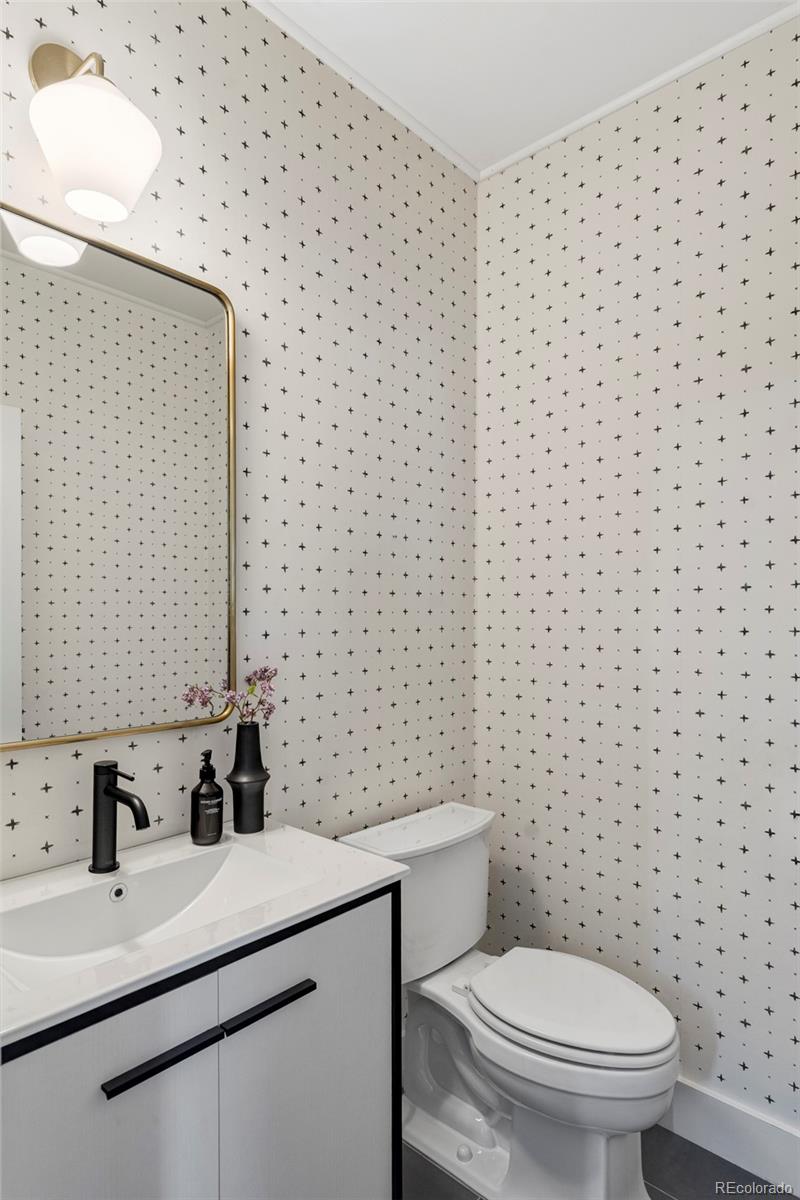 2908 Ironton Street Denver, CO 80238 - Photo 12 of 30 a bathroom with a granite countertop toilet a sink a mirror and a shower
