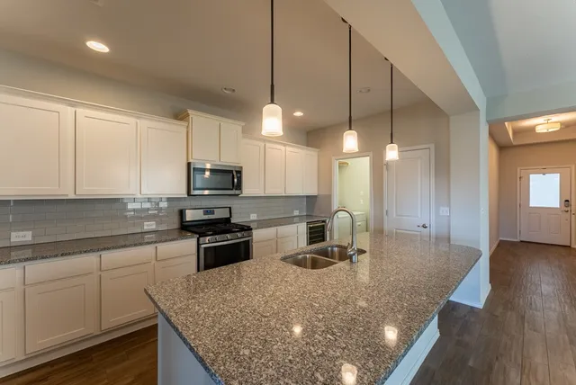 a kitchen with a sink a counter top space cabinets and stainless steel appliances