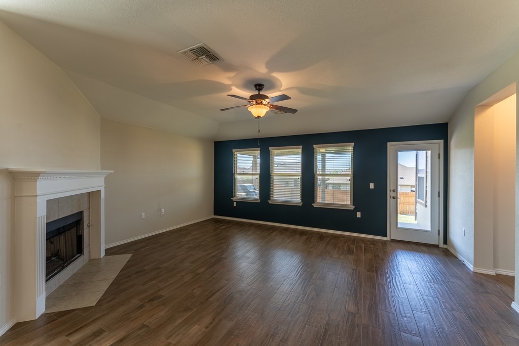 7304 Van Ness Street Austin, TX 78744 - Photo 17 of 37 a view of an empty room with wooden floor and a fireplace