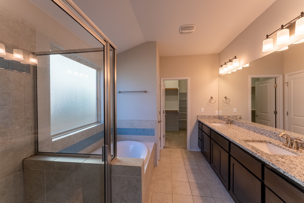 7304 Van Ness Street Austin, TX 78744 - Photo 21 of 37 a bathroom with a granite countertop sink a mirror and a shower