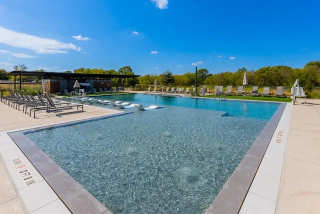 a view of a swimming pool with lounge chairs in the patio