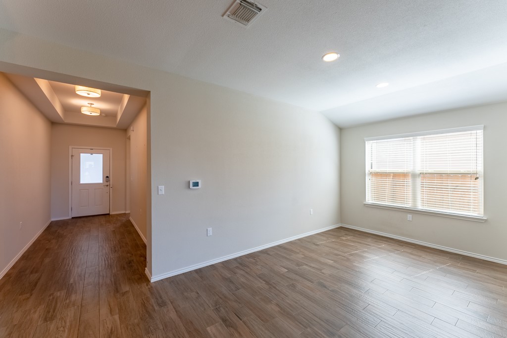 7304 Van Ness Street Austin, TX 78744 - Photo 4 of 37 an empty room with wooden floor and windows