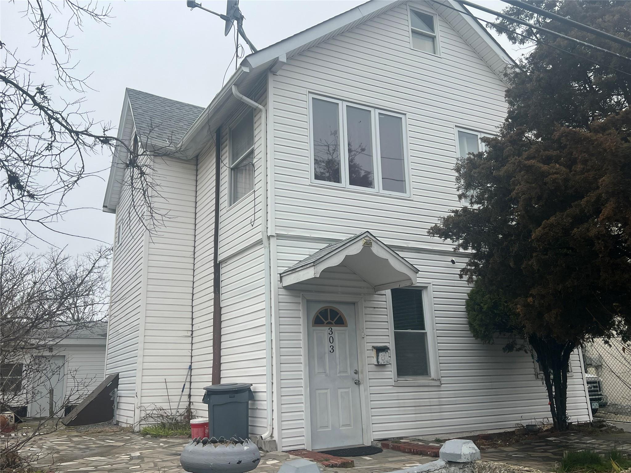 303 Beach 84th Street Queens, NY 11693 - Photo 2 of 16 View of front facade featuring roof with shingles
