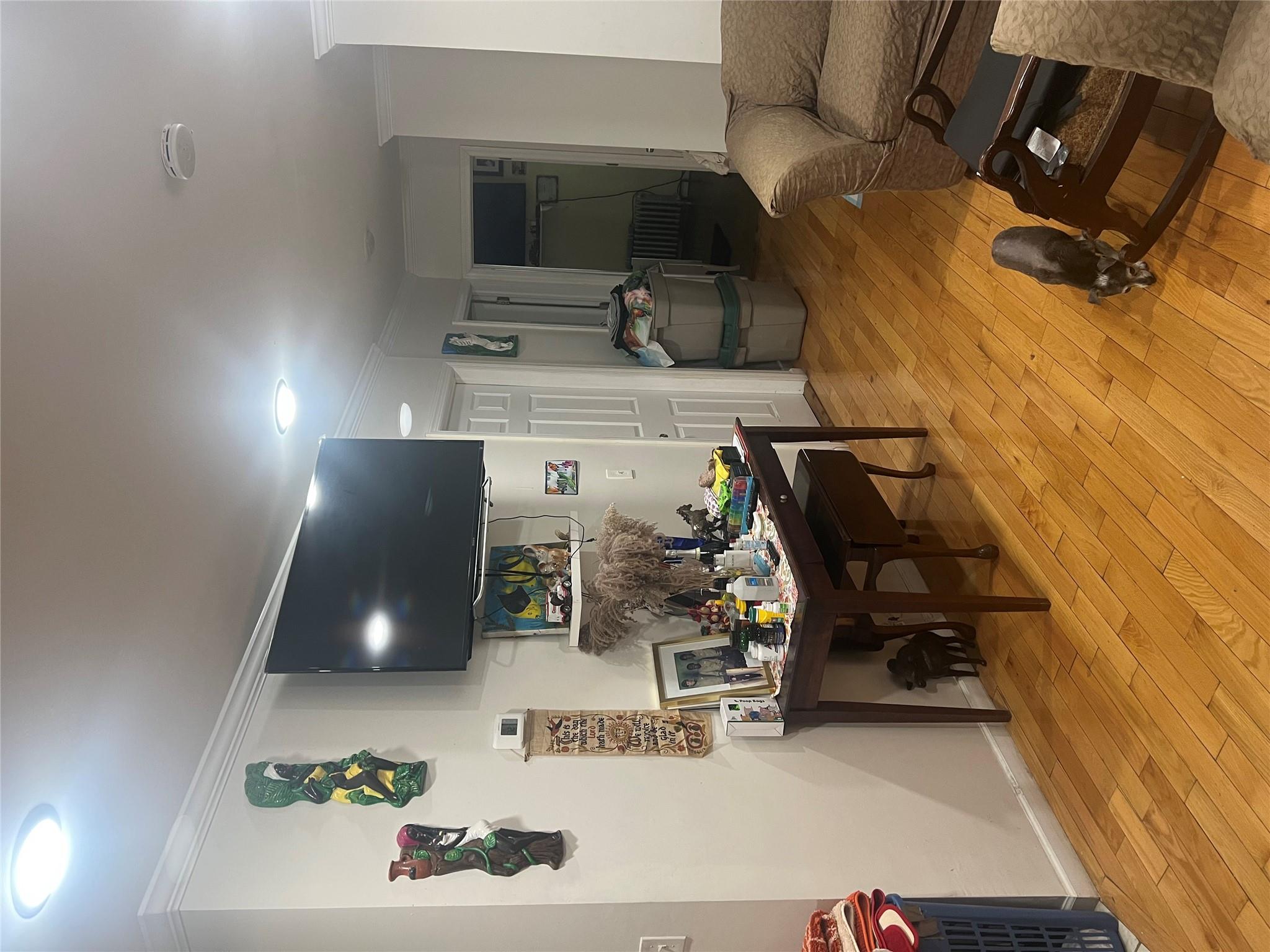 303 Beach 84th Street Queens, NY 11693 - Photo 7 of 16 Living room featuring radiator, baseboards, light wood-style floors, and ornamental molding
