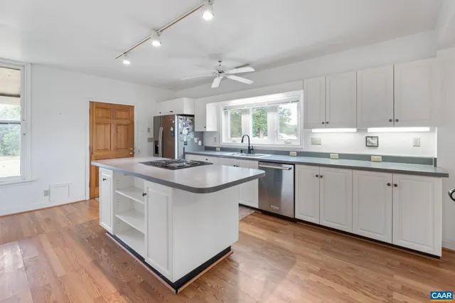 a kitchen with a sink cabinets a window and appliances