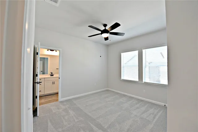 a view of empty room with wooden floor and ceiling fan