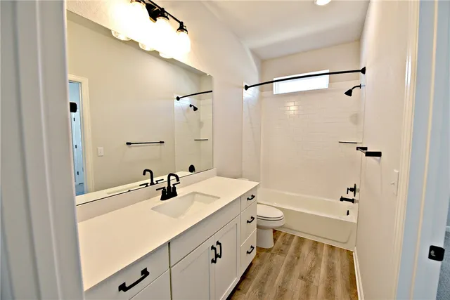 a bathroom with a sink a toilet a shower and a mirror