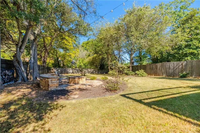 a view of a backyard with swimming pool and sitting area