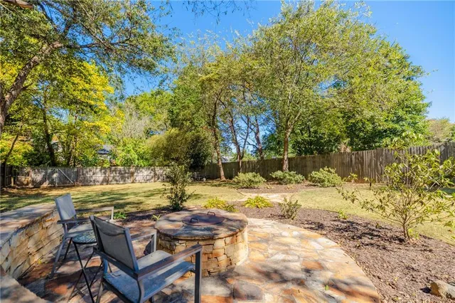 a view of a house with swimming pool next to a big yard