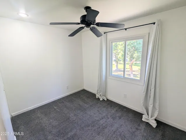 a view of a room with a ceiling fan and a window
