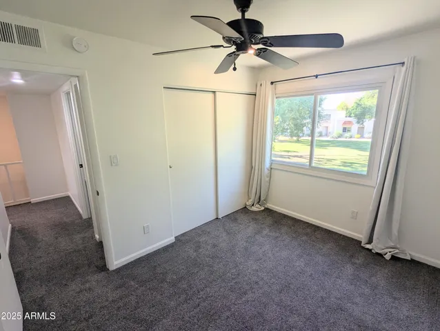 an empty room with a ceiling fan and a window