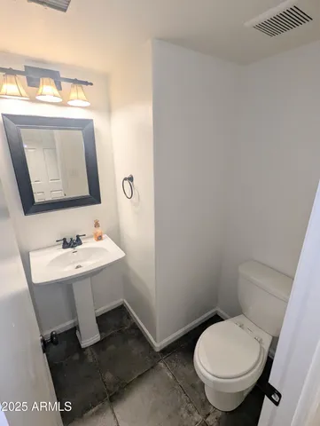 a bathroom with a toilet a sink and mirror