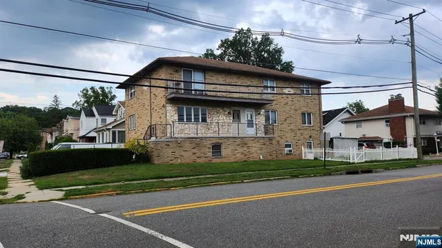a view of a white house with a big yard and large trees
