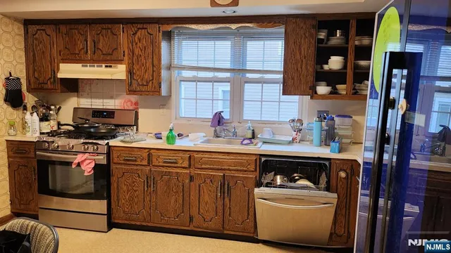 a kitchen with stainless steel appliances a stove and cabinets