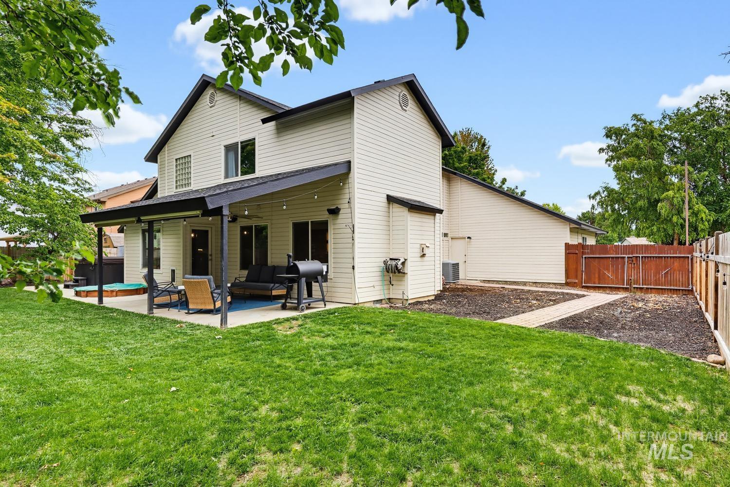 369 South Winthrop Way Boise, ID 83709 - Photo 40 of 50 Expansive backyard featuring a covered patio, hot tub, and a manicured lawn