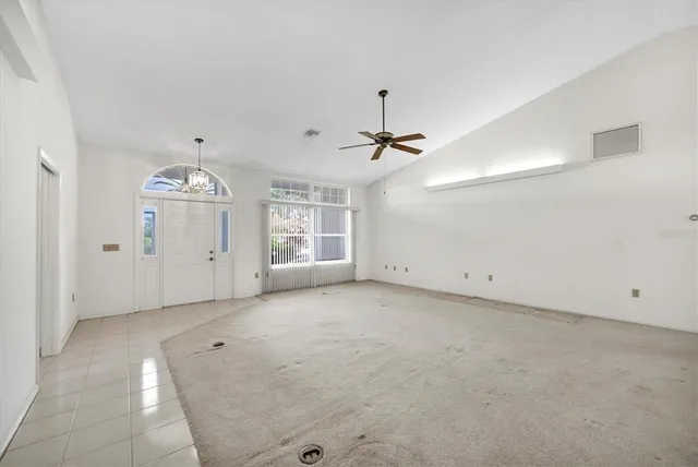 an empty room with a ceiling fan and window