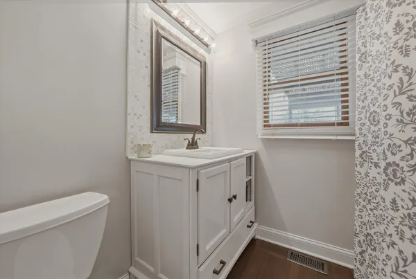 a bathroom with a sink a toilet and a mirror