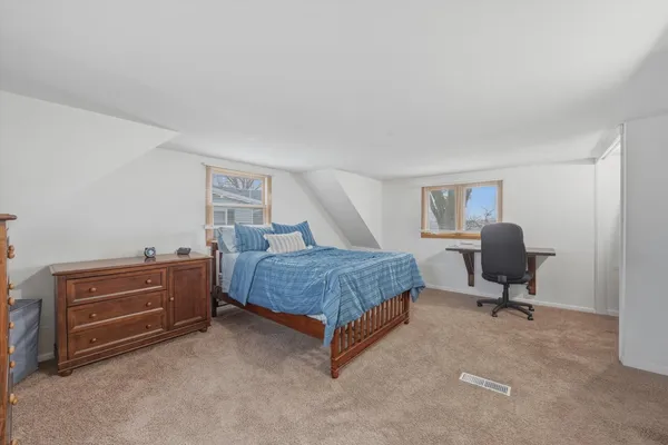 a bedroom with a bed and a chair in it