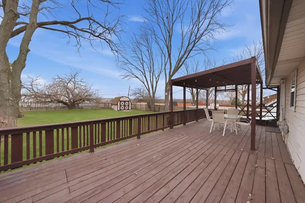 a view of house with deck outdoor seating and wooden floor