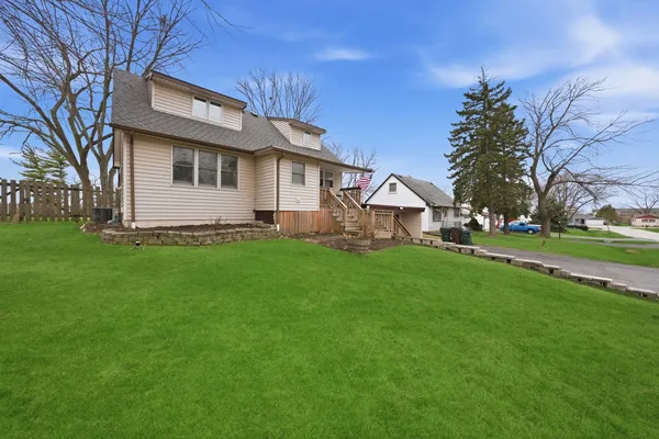 a front view of a house with a yard and trees