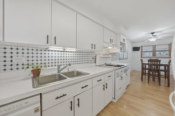 a kitchen with granite countertop a sink a stove and cabinets