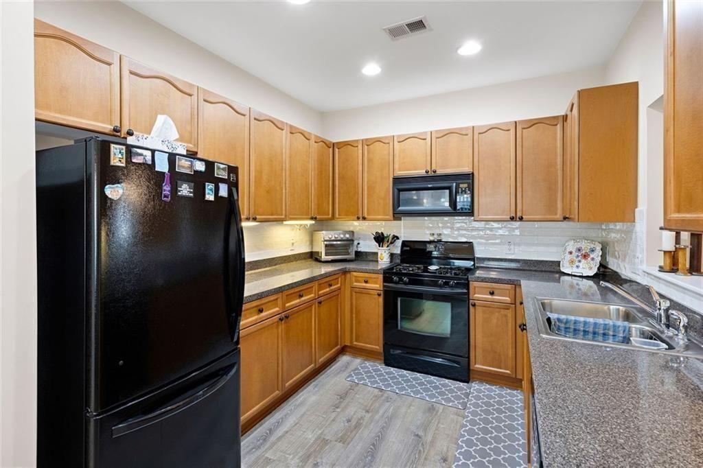 3807 Abbott Lane Southwest, Unit 15 Powder Springs, GA 30127 - Photo 13 of 32 a kitchen with granite countertop stainless steel appliances and wooden cabinets