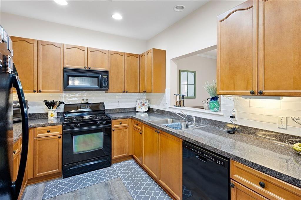 3807 Abbott Lane Southwest, Unit 15 Powder Springs, GA 30127 - Photo 14 of 32 a kitchen with stainless steel appliances granite countertop a sink stove and microwave